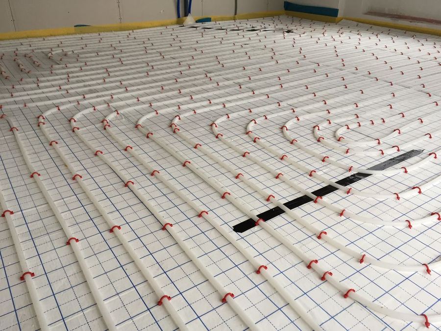 Verlegte Fußbodenheizungsrohre auf Tackerplatten in einem Rohbau
