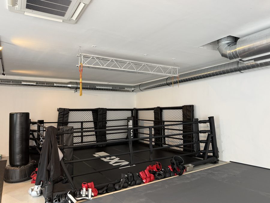 MMA-Käfig im Trainingssaal, an der Decke die verzinkte Lüftungskanalführung